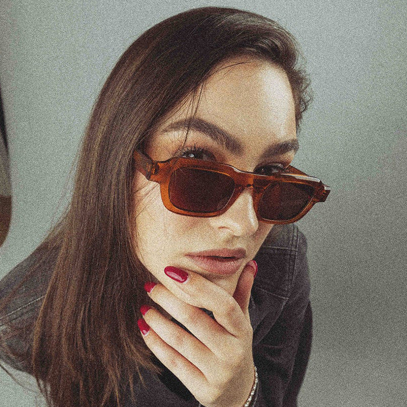 A woman wearing retro small square frames and simple sunglasses